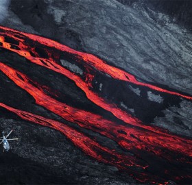 Helicopter Flies Over Lava Flows