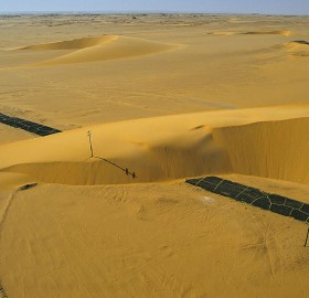 road interrupted by a sand dune