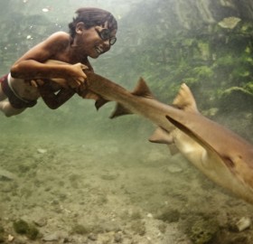 happy kid with his pet shark, indonesia